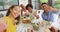 Group of diverse male and female friends making video call at dinner party on patio