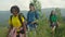 Group of diverse multiracial hikers with backpacks enjoying mountain hiking at sundown