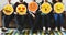 Group of diverse people holding emoticon icons