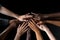 Group of diverse people putting hands together on black background, closeup, Team members high-fiving close-up, Hands visible only
