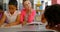 Group of diverse schoolkids studying together at table in school library 4k