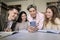 Group of diverse schoolmates using smartphone in library