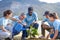 group of diverse volunteers planting trees in evening sun