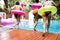 Group of diverse women jumping to the pool with inflatable tube