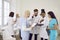 Group of doctors and nurses in hospital staff room discussing something together