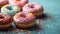 A group of doughnuts with pink frosting and sprinkles