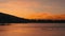 A group of ducks on the surface of the water during sunset.