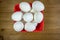 A group of eggs inside a deep red bowl waiting for the chef to use them in a meal