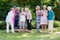 Group of elderly ladies at a care home enjoying a stimulating creative art class outdoors in a garden or park.