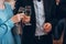 Group of elegant people holding glasses of champagne at luxury w