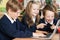 Group Of Elementary School Children Working Together In Computer