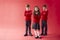 Group Of Elementary School Pupils Wearing Uniform Folding Arms Against Red Studio Background