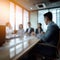 A group of employees are sitting in a meeting room through a blurred lens