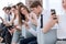 Group of employees using their gadgets sitting in the office hallway