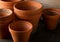 Group of empty, used terracotta planting pots on wooden table