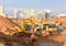 Group of the excavators working on dig ground trenching at construction site. Backhoe on groundwork / road work. Commercial and