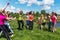 Group of excited women crossing the finshline a marathon running on grassy land in park.