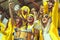 Group of fans dressed in yellow color watching a sports event