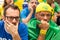 Group of fans watching a match and cheering brazilian team.