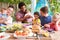 Group Of Fathers With Children Enjoying Outdoor Meal At Home