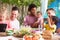 Group Of Fathers With Children Enjoying Outdoor Meal At Home