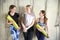 Group of female friends in sportswear smiling together while standing in a gym after yoga workout. Women standing by a