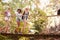 Group Of Female Friends On Walk Crossing Wooden Bridge