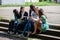 a group of female students sitting with books in the courtyard of the university