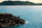 Group of fishermen fishing on rock pier at sunset with calm blue sea