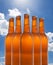 A group of five beer bottles in a diamond formation on sky background.