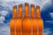 A group of five beer bottles in a diamond formation on sky background.