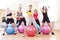 Group of Five Caucasian Female Athletes Having Exercises With Fitballs in Gym and Showing