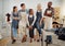 Group of five cheerful diverse clothing designers standing with their arms crossed in a shop at work. Joyful tailors