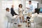 Group of five diverse businesspeople having a meeting in an office at work. Hispanic businesswoman reading a report to