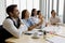 Group of five diversity businessmen, two men and three women sitting at meeting desk and pay attention with satisfied laugh for