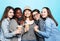 Group of five girls friends of different nationalities holding a cup of coffee