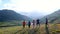 Group of five happy friends jumps at sunset time on background mountains aerial slow motion 1080p