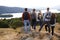 A group of five mixed race young adult friends admire the view after arriving at summit after a mountain hike, back view, close up