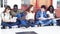 Group of five multi ethnic teenager students seated on school hallway working with textbooks. Slow motion