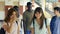 Group of five multi ethnic teenager students smiling and walking. Slow motion