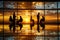 A group of five professionals in a contemporary office, silhouetted against a sunset window. Reflective floor. Corporate