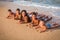 Group of five smiling kids lying down on the beach