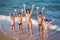 Group of five smiling kids standing on the beach