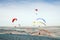 A group of flying paragliders on a background of blue sky