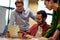 Group of focused multiracial business people looking at laptop screen and discussing work or project results while