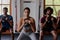 Group of focused multiracial young adults doing kettlebell squats at the gym