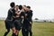 Group of football players excited on scoring a goal. Footballers coming together in a huddle celebrating victory on the field