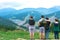 Group of Four best friends laughing and having a good time while hiking in wild forest, beauty of nature. People look on forest la