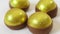 a group of four chocolate eggs with gold foil on them