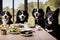 A group of four dogs sitting at a table with food. Dinner for animals concept.